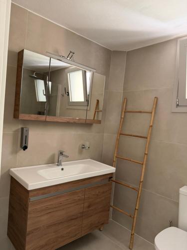 a bathroom with a sink and a mirror at Almyra Suites in Khalíkia