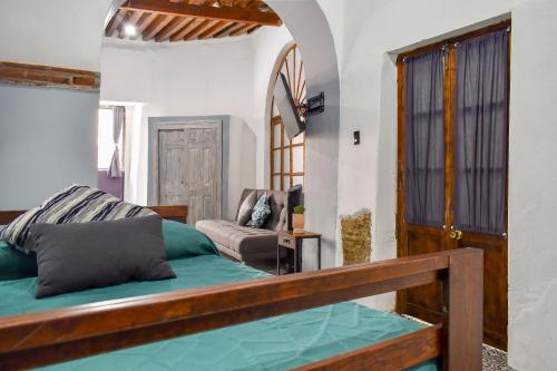 a bedroom with a bed and a chair in a room at Doña Vicenta Casa Colonial in Guanajuato
