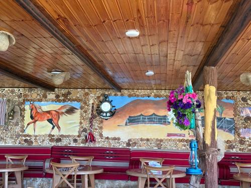 a restaurant with a painting of a horse on the wall at Dana panorama-green camp in Dana