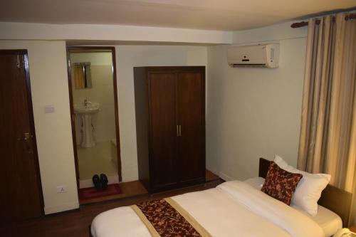 a hotel room with a bed and a bathroom at Hotel Yambu kathmandu in Kathmandu