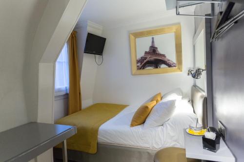 1 dormitorio con 1 cama con la torre Eiffel en Pratic Hotel, en París