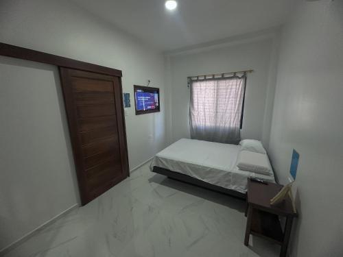 a small bedroom with a bed and a window at San Cristóbal Surf House lll in Puerto Baquerizo Moreno