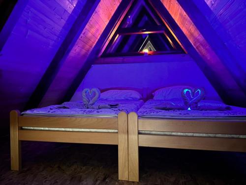 a bed in a room with purple lighting at Vikendica Golubicanka in Bihać