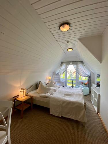 a bedroom with a large white bed and a window at Spicīte in Ventspils