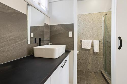 a bathroom with a white sink and a shower at Carrum Downs Motel in Carrum Downs