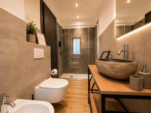 a bathroom with a bowl sink and a toilet at Sweet Alps in Tirano