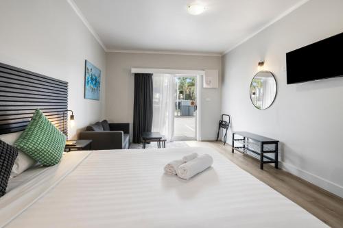 a bedroom with a large white bed with two towels at Carrum Downs Motel in Carrum Downs