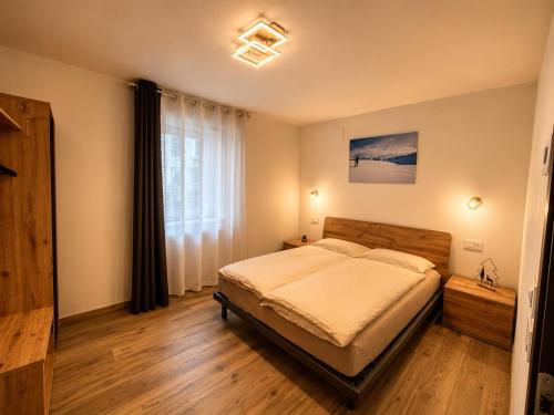 a bedroom with a bed and a large window at Sweet Alps in Tirano