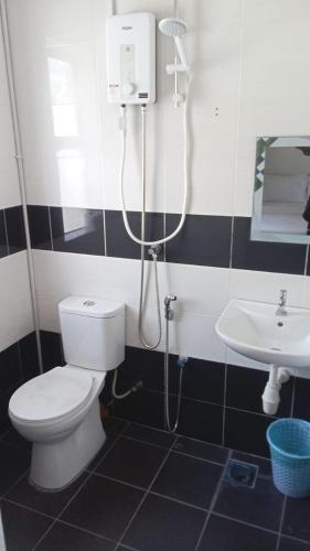 a bathroom with a shower and a toilet and a sink at Pusing Classic Semi D House in Pusing