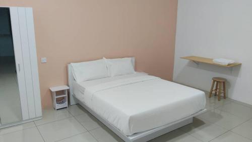 a white bed in a room with a small table at Pusing Classic Semi D House in Pusing