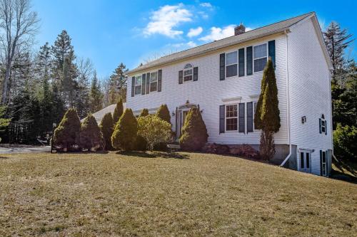 a white house with a large yard at Spacious Seven Peaks Ridge Quiet Side Hot Tub, Pet Friendly, Fire Pit & Deck in Southwest Harbor
