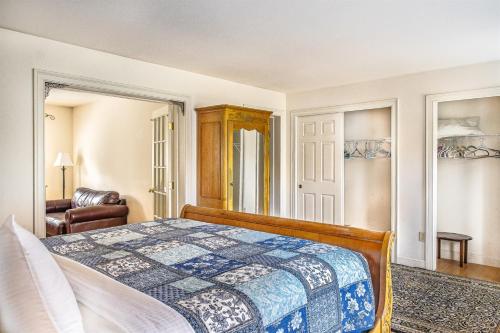 a bedroom with a bed and a chair at Spacious Seven Peaks Ridge Quiet Side Hot Tub, Pet Friendly, Fire Pit & Deck in Southwest Harbor