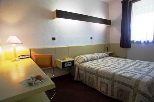 une chambre d'hôtel avec un lit et un bol de fruits sur une table dans l'établissement Le Relais de Fabrègues, à Fabrègues