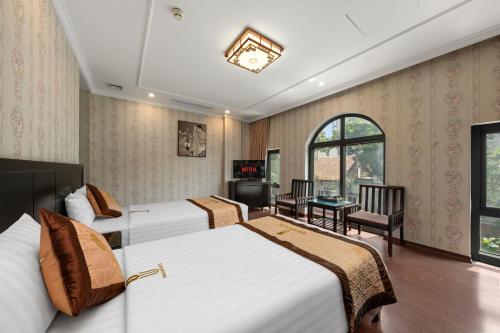 a hotel room with two beds and a television at Binh Anh Hotel in Hanoi
