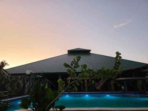 a house with a black roof and a swimming pool at Gilkrissa Garden in San Nicolas
