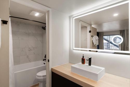a white bathroom with a sink and a mirror at The Hotel Pendleton, Trademark Collection by Wyndham in Pendleton