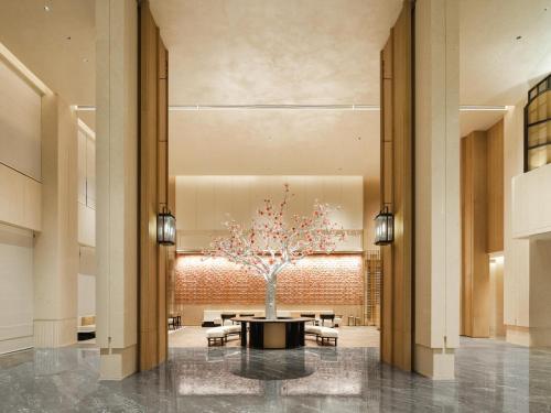 a lobby with a tree in the middle at Canton Hotel Guangzhou, Tapestry Collection By Hilton in Guangzhou