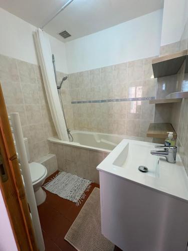 a bathroom with a sink and a toilet and a tub at Grande chambre in Agde