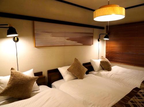 two beds in a room with white sheets and pillows at #52 Towny Yanagihara in Numazu