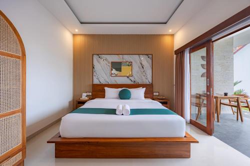 a bedroom with a large bed and a table at Cove Tegeh Bila in Ungasan