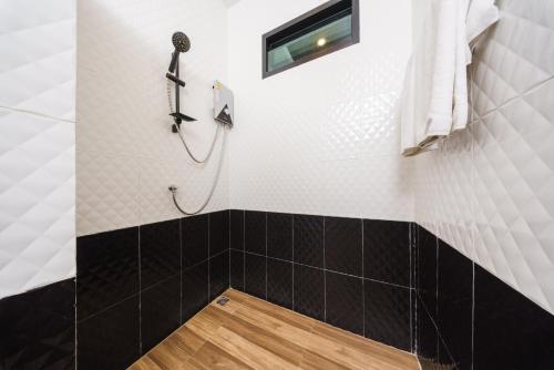 a bathroom with a shower with black and white tiles at Villa Escape Aonang Krabi in Krabi