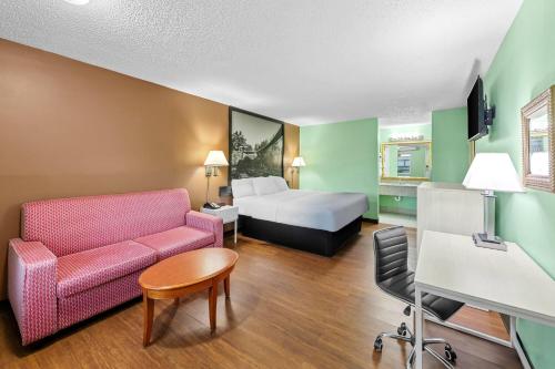 a hotel room with a couch and a bed at Super 8 by Wyndham Gaffney in Gaffney