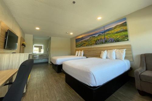 a hotel room with two beds and a couch at Days Inn by Wyndham Near Seaworld San Antonio in San Antonio