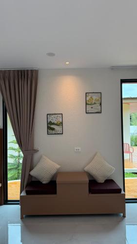 a room with a bed with a window and a curtain at ภัสรา รีสอร์ท in Ban Nong Khla