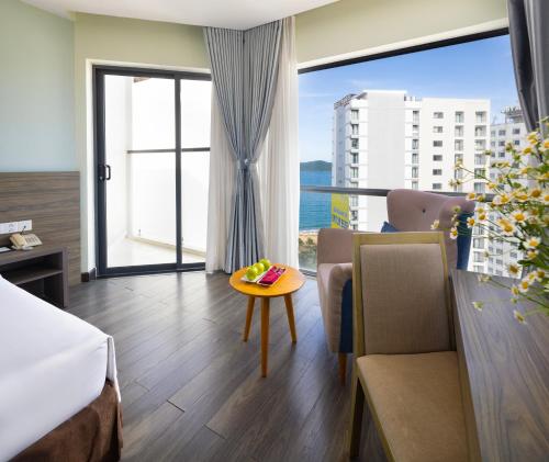 a hotel room with a bed and a table and a window at Xavia Hotel in Nha Trang