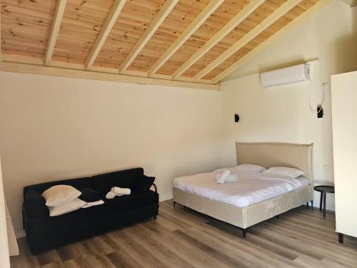 a bedroom with a bed and a couch at Velen Harmony- בקתות מושלמות עם בריכה במתחם in ‘Ein el Asad