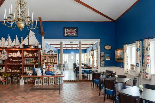 een eetkamer met blauwe muren en tafels en stoelen bij Hotel Slottsgården in Vadstena