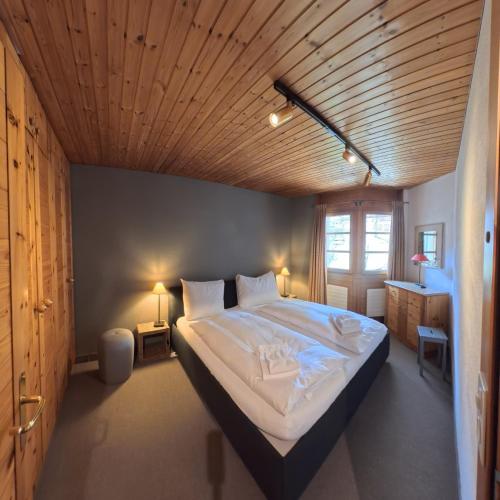 a bedroom with a large bed with a wooden ceiling at Alpen-Retreat mit Spa in Lenzerheide