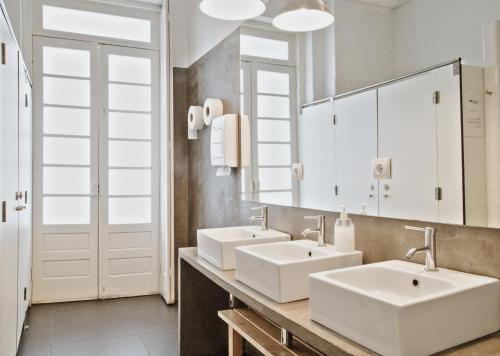
a bathroom with a sink, mirror, and bathtub at Porto Spot Hostel in Porto
