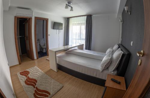 a bedroom with a large bed and a bathroom at Elegant Private Villa with 3 Bedrooms, Office, and shared courtyard, Perfect for 8 Guests in Piteşti