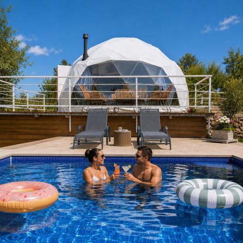 a man and woman sitting in a swimming pool at Casa del mir in Dayr al Qamar