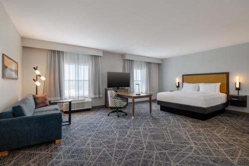 a large hotel room with a bed and a couch at Hampton Inn & Suites West Des Moines Mill Civic in West Des Moines