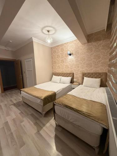 ein Schlafzimmer mit zwei Betten und einer Ziegelwand in der Unterkunft KONAK HOTEL 2 in Kars
