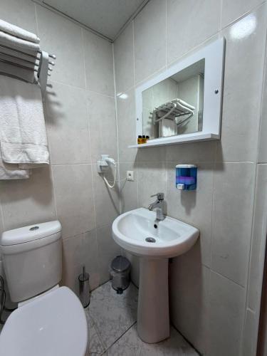 ein weißes Badezimmer mit Toilette und Waschbecken in der Unterkunft KONAK HOTEL 2 in Kars