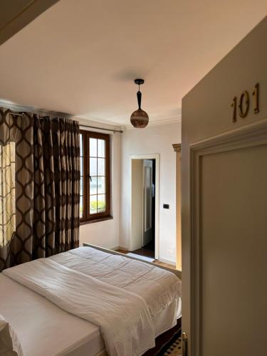 a bedroom with a bed and a window at Oda Kuksit Hotel in Kukës