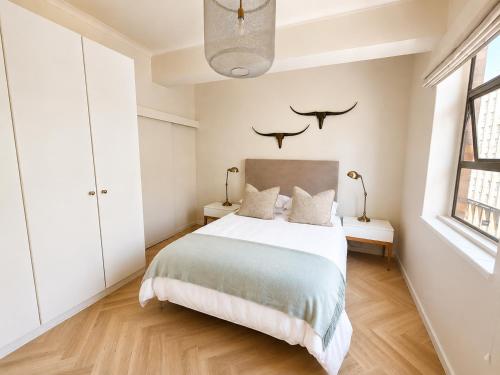 a bedroom with a bed and two birds on the wall at Cape Central Designer Suite in Cape Town