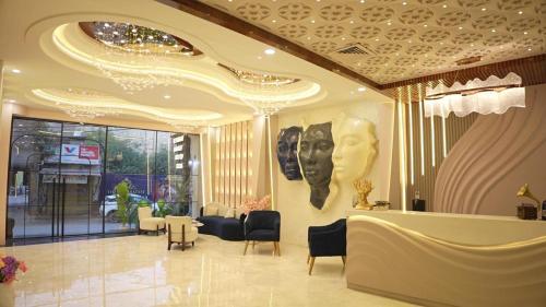 a lobby with a waiting area with chairs and a table at Thejaiparadise by jai hotel in Rohtak