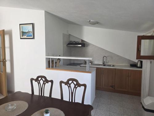 a kitchen with a table and chairs and a sink at Apartman Mihaela in Komiža