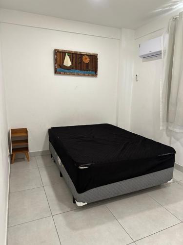 a bed in a room with a black mattress at Apartamento 2 quartos 100m Prainha in Arraial do Cabo