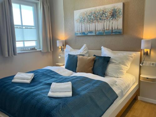 a bedroom with a large bed with two towels on it at Ferienhaus Sundevit - exklusives Ferienhaus mit Infrarotsauna, Whirlpool-Wanne und Kamin in Putgarten