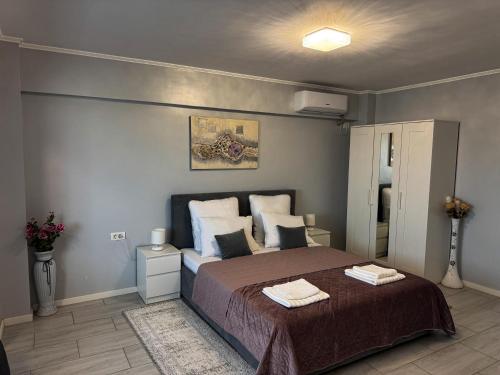 a bedroom with a large bed with two towels on it at A&C Studio Techirghiol in Techirghiol