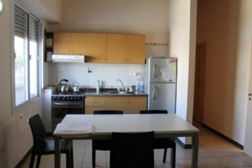 a kitchen with a table and chairs and a refrigerator at Bet Hotel Buenos Aires in Buenos Aires