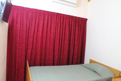 a bedroom with a red curtain and a bed in front at Bet Hotel Buenos Aires in Buenos Aires