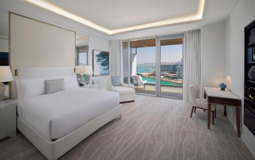 a white bedroom with a white bed and a desk and a desk at Waldorf Astoria Doha Lusail in Doha