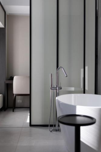 a bathroom with a bath tub and a table at Manho Hotel in Taichung