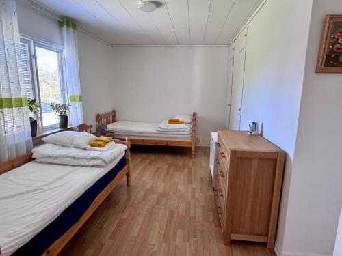 a room with two beds and a dresser in it at KalmarStay in Blomstermåla